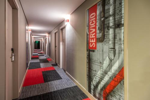 a long hallway with a red sign on the wall at ibis Chia in Chía