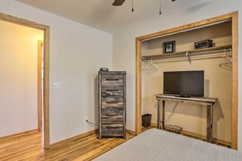 a bedroom with a bed and a desk with a television at Rapid City Home - Walk to Canyon Lake Park in Rapid City