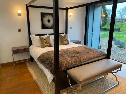 een slaapkamer met een hemelbed en een raam bij The Farmyard Adults Only in Yeovil