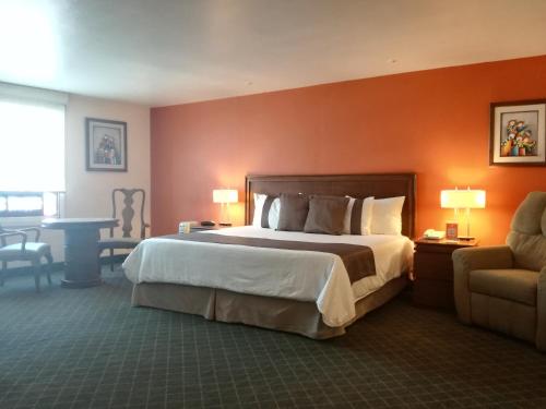パチューカ・デ・ソトにあるMision Express Pachucaの大きなベッドと椅子が備わるホテルルームです。