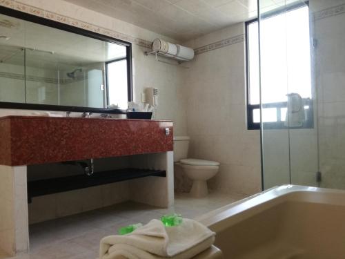 y baño con bañera, lavabo y aseo. en Mision Express Pachuca, en Pachuca de Soto