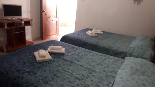 two beds in a room with towels on them at Hostal Villa Brisa in Ballenita