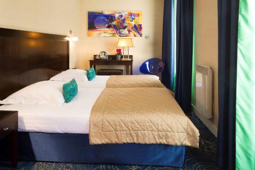 a hotel room with a bed in a room at Hotel Best Western Anjou Lafayette in Paris