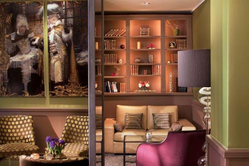 a living room with a couch and a book shelf at Hotel Best Western Anjou Lafayette in Paris