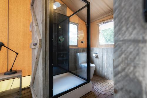 a bathroom with a glass shower in a tiny house at Castlemaine Gardens Luxury Safari Tents in Castlemaine