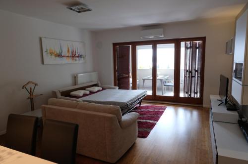 Sala de estar con sofá, cama y TV en Apartment Summertime, en Crikvenica