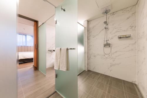 a bathroom with a shower and a glass door at Howard Johnson by Wyndham Incheon Airport in Incheon