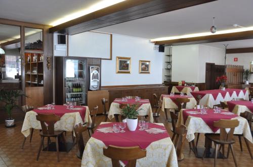 a restaurant with red and white tables and chairs at Casa Alpina Dobbiaco in Dobbiaco