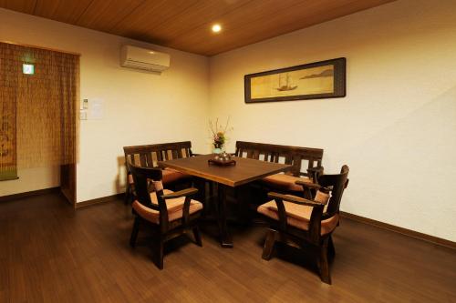 a dining room with a wooden table and chairs at Shirakabanoyado-MAMEMACHIIE, 1min to Tsutenkaku, 白樺の宿-豆町家 in Osaka