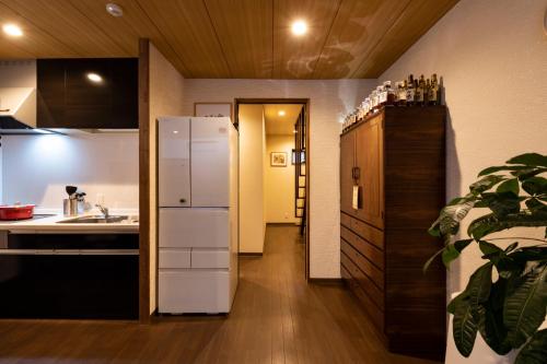 a kitchen with a refrigerator and a sink at Shirakabanoyado-MAMEMACHIIE, 1min to Tsutenkaku, 白樺の宿-豆町家 in Osaka