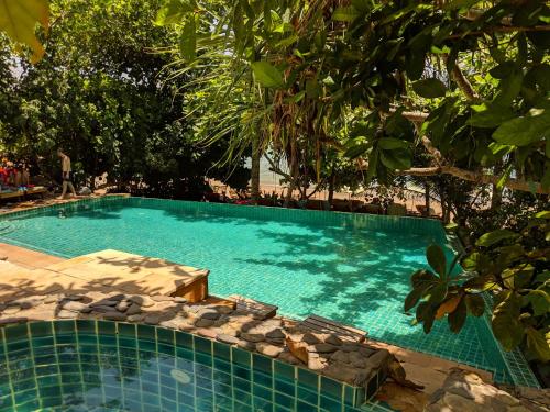 uma piscina com água azul e árvores em The Narima - SHA Plus em Ko Lanta