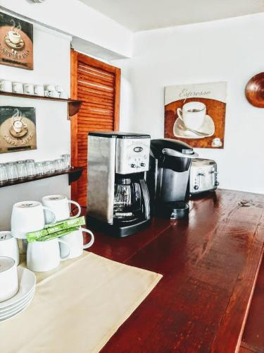 a kitchen with a coffee maker and cups on a counter at Ellen Bay Inn in Saint Philips