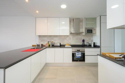 a white kitchen with white cabinets and appliances at Linara in San Juan de los Terreros