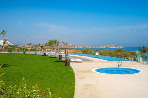 a resort with a swimming pool and a grass field at Linara in San Juan de los Terreros