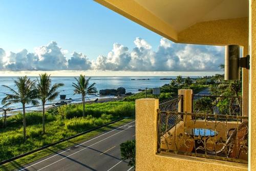 a balcony with a view of a beach and the ocean at Ji Li Ya Lan Homestay in Chenggong
