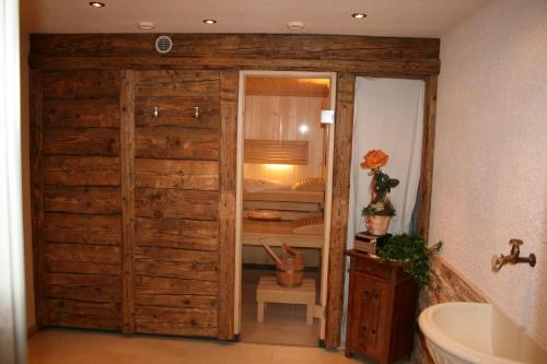 カップルにあるAparttanjaの木製のドア付きのバスルーム(シンク、バスタブ付)