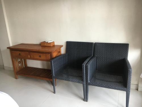two chairs and a wooden table with a box on it at Amed Sunset Beach in Amed