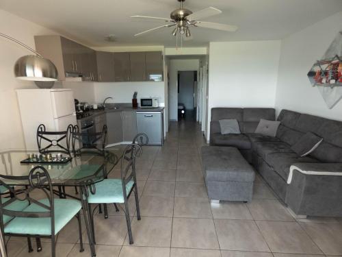 a living room and kitchen with a couch and a table at Palm Beach in Le Gosier