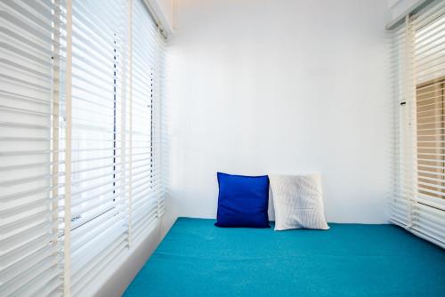 a blue pillow sitting in a room with windows at Baan KangMung Hua Hin On The Beach in Hua Hin