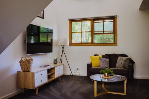a living room with a couch and a table at Lothlorien in Mount Beauty