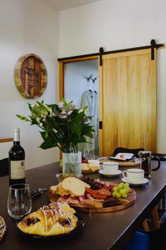 a table with plates of food and a bottle of wine at Lothlorien in Mount Beauty