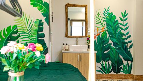 ein Badezimmer mit einem Waschbecken und einer Blumenvase mit einem Spiegel in der Unterkunft Cherry Apartment - Thao Dien Centre in Ho-Chi-Minh-Stadt