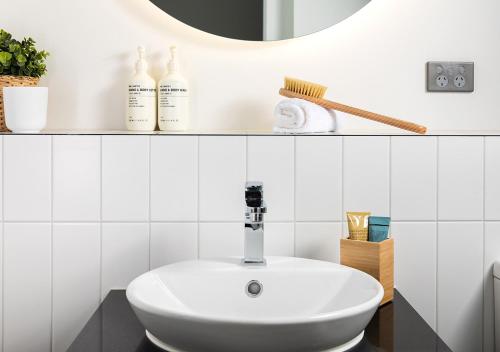 bagno bianco con lavandino e specchio di Scape Living at Aurora a Melbourne
