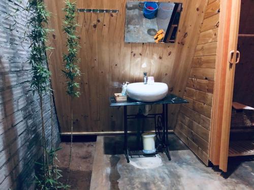 baño con lavabo en una pared de madera en Nhà của Nếp en Plei Brel (2)