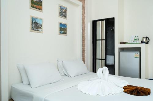 a white bed with a towel on top of it at Baron Zotel Bangkok SHA PLUS in Bangkok