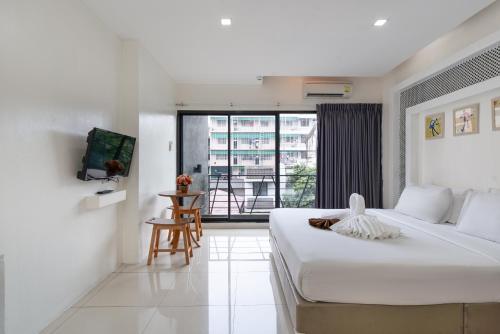 ein Schlafzimmer mit einem großen Bett und einem Balkon in der Unterkunft Baron Zotel Bangkok SHA PLUS in Bangkok