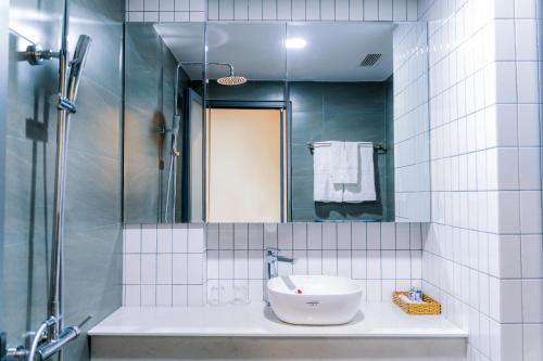 een badkamer met een wastafel en een spiegel bij KADUPUL HOTEL in Quy Nhon