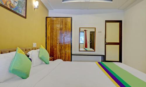 a bedroom with a white bed and two mirrors at Hotel Lake Paradise Mahabaleshwar in Mahabaleshwar