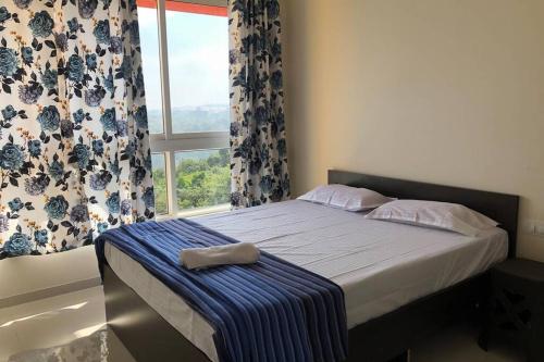 a bed in a bedroom with a window with curtains at Birdsnest Seaview Holiday Home in Dabolim