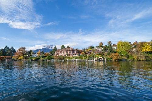 vista su un lago con case sullo sfondo di Seehotel Kastanienbaum a Lucerna