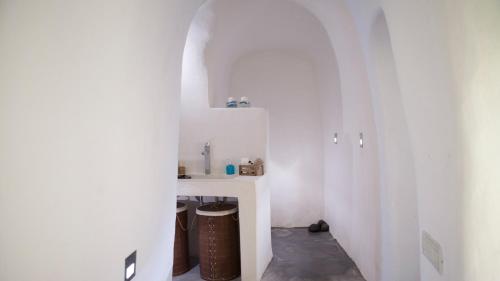 - un couloir blanc avec lavabo dans la chambre dans l'établissement Oia, Finikia Cave House, à Oia