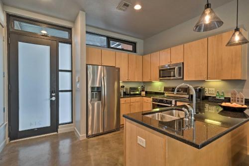 a kitchen with a stainless steel refrigerator and wooden cabinets at Urban Escape in SoLA with Private Patio! in Austin