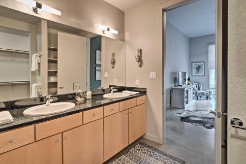 a bathroom with two sinks and a large mirror at Urban Escape in SoLA with Private Patio! in Austin