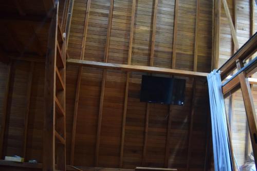 Habitación con TV en una pared de madera. en Wonderful Citamiang by Anrha, en Puncak