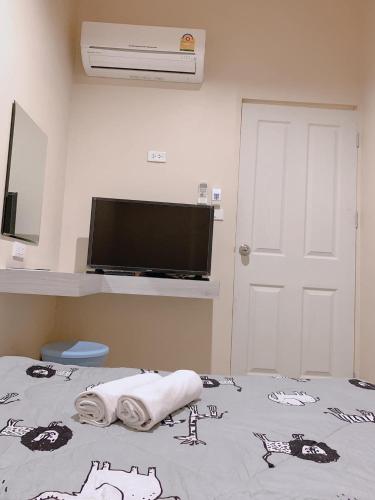 a room with a bed with a flat screen tv at Sleepbox Hostel Suratthani in Suratthani