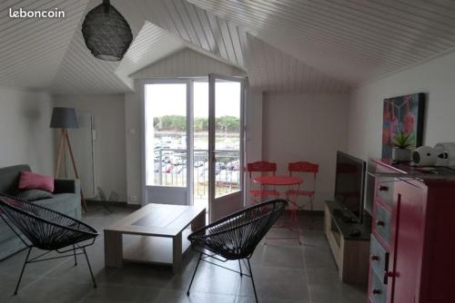 ein Wohnzimmer mit Stühlen, einem Tisch und einem Sofa in der Unterkunft APPARTEMENT FACE au PORT et à L'OCEAN SAINT GILLES CROIX DE VIE WIFI BALCON PARKING PRIVE COUVERT in Saint-Gilles-Croix-de-Vie