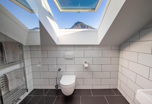 a bathroom with a toilet and a skylight at Apartmenthotel Oberstdorf in Oberstdorf