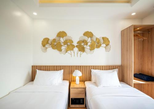 two beds in a room with white sheets at Ann Hotel & Spa Khem Beach PQ in Phú Quốc