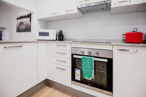 a kitchen with white cabinets and a red appliance at El Niu de Escaldes in Escaldes-Engordany