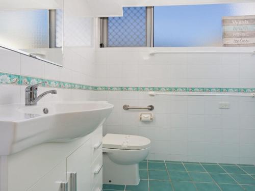 Un baño blanco con lavabo e inodoro. en Oceanic 2 On Main Beach, en Forster