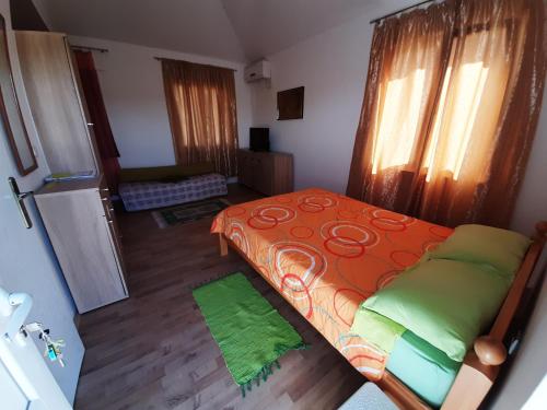 a small bedroom with a bed and a refrigerator at Termalna Rivijera Apartmani in Bogatić