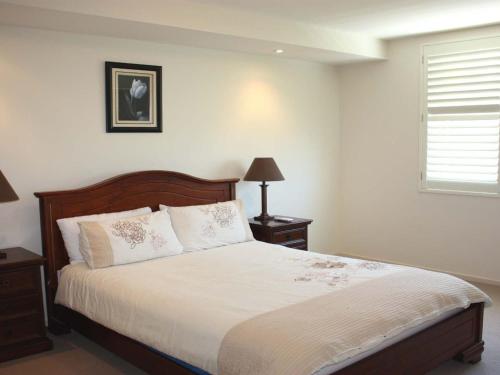 a bedroom with a bed and a window at The Reef 103 Lakeside in Forster