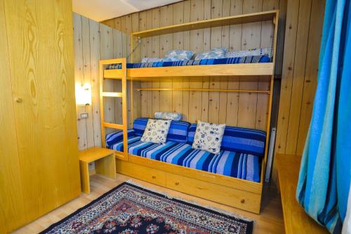 two bunk beds in a room with a rug at Res. Amba appartamenti Solandra in Mezzana