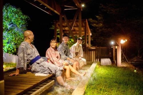 a group of people sitting on a bench at night at Konjakutei in Aizuwakamatsu