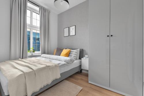 biała sypialnia z łóżkiem i oknem w obiekcie HARBOR APARTMENTS - Zabrska w mieście Katowice