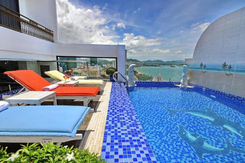 una piscina con 2 sillas y una piscina en Boss Hotel, en Nha Trang